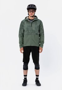 Roheline veekindel jope lukuga ees, ühendatud mustade lühikestega. Sisaldab kiivrit, prille ja polsterdatud põlvekaitsmeid.