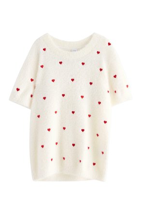 Witte short-sleeve trui van fluffy materiaal, voorzien van verspreide kleine rode hartpatronen over het kledingstuk.
