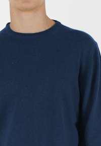 Granatowy sweter dzianinowy z okrągłym dekoltem i długimi rękawami, charakteryzujący się miękką teksturą i klasycznym krojem. Minimalistyczny design bez wzorów.