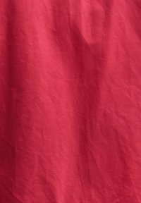 Φωτεινό κόκκινο ύφασμα με ορατές γραμμές τσακίσματος και ελαφριά υφή σε όλο το μήκος.