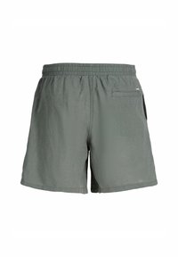 Mörkgröna shorts i lätt material. Har ett elastiskt midjeband, diskret sömnad och en bakficka. Slät yta.