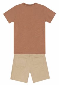 Bruine short-sleeve t-shirt met een ronde hals boven beige shorts met twee achterzakken en een soepele textuur.