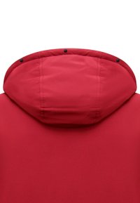 Rode jas met capuchon; gladde stof; opvallende stiksels; zwarte drukknoopsluitingen langs de rand. Achteraanzicht richt zich op de vorm van de capuchon.