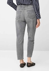 Grijze denim jeans met een aansluitende pasvorm en rechte pijpen, voorzien van twee achterzakken en een tailleband op normale hoogte. Draag ze met zwarte mesh instapschoenen.