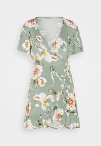 Zielona sukienka w kwiaty z krótkimi rękawami, z białymi i pomarańczowymi kwiatami, falbaną u dołu oraz dekoltem w kształcie litery V.