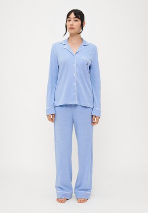 Conjunto de pijama azul claro com parte de cima de botão de manga longa, com bainha branca em contraste, e calças largas combinando. Tecido macio e texturizado.