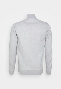 Sudadera gris con cuello alto, mangas largas, puños y dobladillo de canalé, hecha de un tejido suave y texturizado, con un diseño liso.