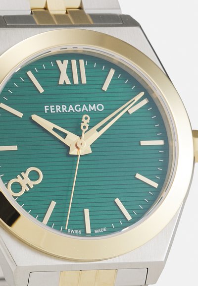 Ferragamo watch with a green textured dial, gold accents, gold and silver stainless steel case, and traditional Roman numeral at 12 o'clock.