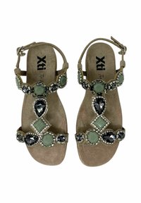 Sandali in suede beige con cinturini decorati da pietre verdi e nere, dettagli in argento e una soletta imbottita.