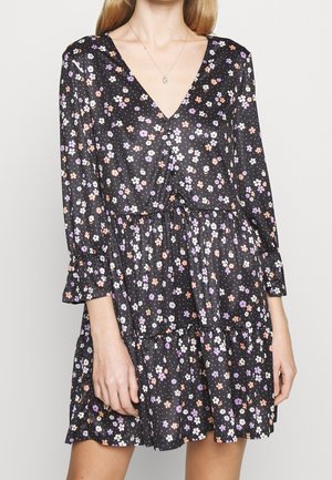 Schwarzes Blümchenkleid mit langen Ärmeln, V-Ausschnitt und geschichteter Rockpartie. Mit bunten Blumenmustern auf einem gepunkteten Hintergrund. Leichter Stoff.