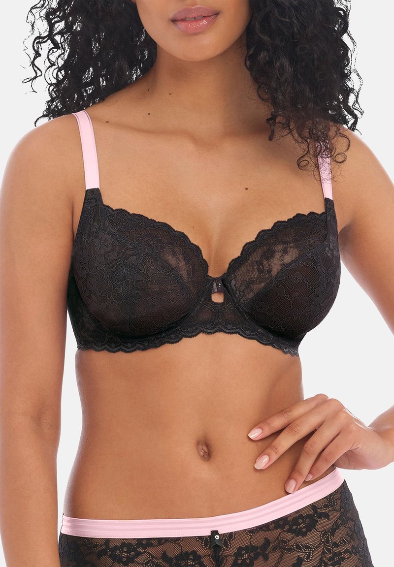 Soutien-gorge en dentelle noire avec des bords festonnés et des bretelles ajustables rose clair, avec un petit détail en forme de serrure au centre frontal.