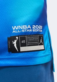 Μπλε φανέλα WNBA 2026 All-Star Edition με ετικέτα μεγέθους 40 με την ένδειξη "Engineered for championship athletes" και λογότυπο Victory.