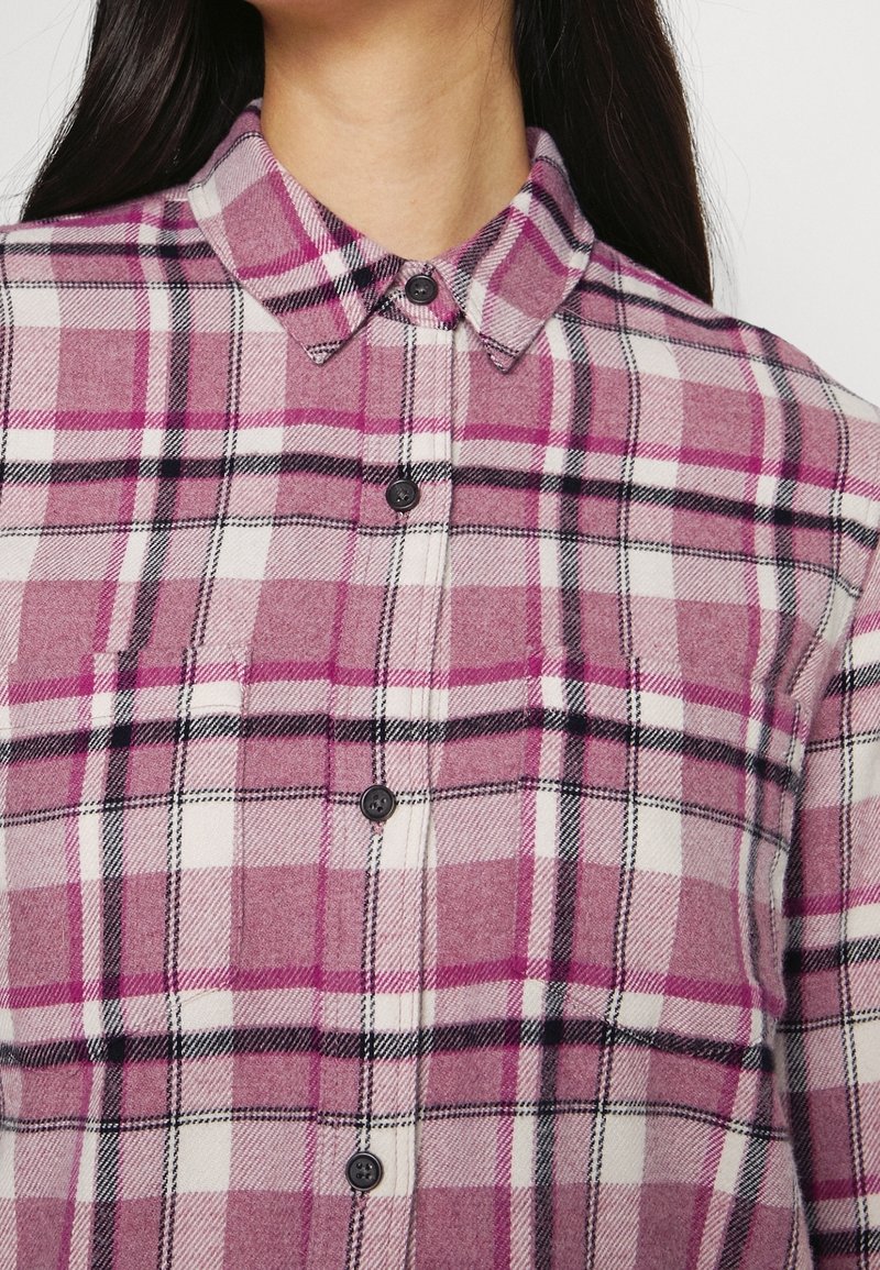 Lila och vit rutigt flanellskjorta med svarta detaljer, med knapplist framtill och en klassisk krage. Mjuk textur.