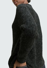 Chunky gebreide trui in donkergrijs met een textuurpatroon, ronde halslijn en een relaxte pasvorm. Voorzien van geribbelde manchetten en onderkant.