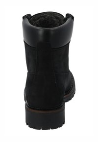 Botín negro de cuero hasta el tobillo, con punta redonda, puño texturizado y suela de goma resistente. Presenta costuras sutiles y un interior forrado de material suave.
