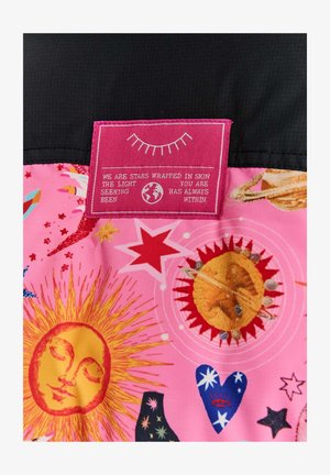 Kolorowy różowy materiał z motywami niebieskimi, w tym słońcami, gwiazdami i planetami. Różowa metka z białym tekstem jest wyraźnie widoczna.