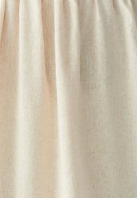 Vaalean beige pellavakangas, jossa on teksturoitu kudonta. Kangas laskeutuu pehmeästi ja siinä on hienovaraiset täplikkäät yksityiskohdat. Soveltuu erilaisiin tekstiilisovelluksiin.