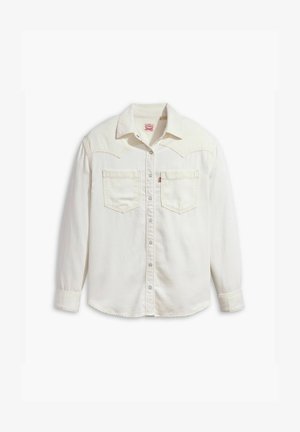 Biała koszula dżinsowa z wyprofilowanym kołnierzykiem, dwoma kieszeniami na piersi i zapięciem na guziki. Subtelne akcenty w postaci przeszyć, długie rękawy z mankietami na guziki.