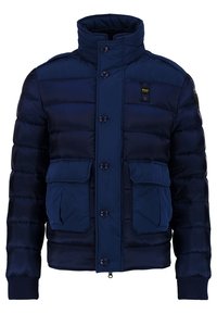 Doudoune bleu marine avec un col montant, cinq boutons et deux poches avant, dotée d'un motif matelassé et de poignets côtelés.