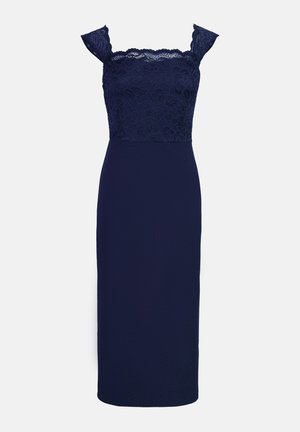 Rochie de seară bleu marin cu un corp din dantelă și bretele căzute de pe umeri, având o siluetă ajustată și tiv la nivelul genunchilor.