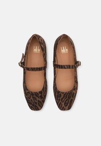 Ballerine in suede con stampa leopardo, punta rotonda, cinturino alla caviglia regolabile e interni in pelle beige. Dettagli in hardware color oro.