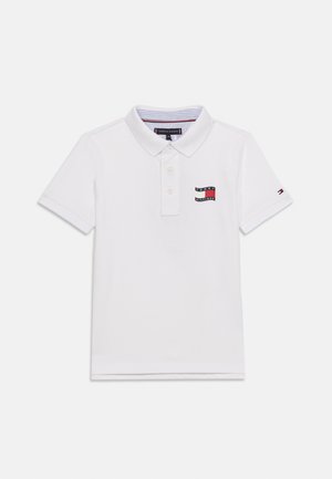 Hvid polo t-shirt med korte ærmer, krave og tre knapper, der har Tommy Hilfiger logo på brystet og et lille flag på venstre ærme.