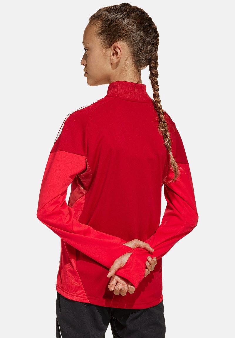 Rode sportieve shirt met hoge kraag, lange mouwen en contrasterende mouwen. Gladde textuur, ontworpen voor comfort en mobiliteit.