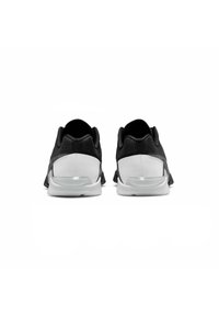 Scarpe da ginnastica nere con tomaia testurizzata, suola bianca e accentuazione trasparente sul tallone. Presentano un collare imbottito e un design a profilo basso.