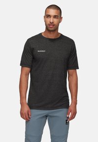 Zwarte korte mouwen T-shirt van structuurstof, met een wit "Mammut" logo op de linkerborst. Casual fit, ronde halslijn.