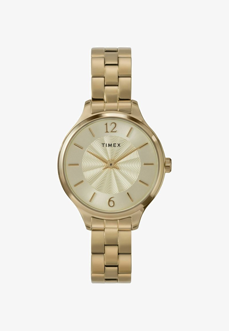 El reloj Timex en tono dorado presenta una caja redonda, un dial crema texturizado con un patrón de olas, y una pulsera de eslabones metálicos a juego. Números en las posiciones de las 12 y las 6.