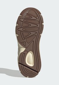 Hnedá gumová podrážka s textúrovaným povrchom, so zigzagovými vzormi a zakrivenými akcentmi. Dizajn obsahuje svetlé detaily.