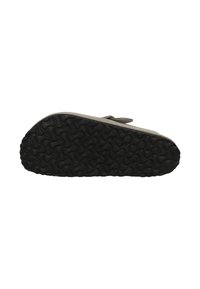 Zwarte rubberen zool met een getextureerd cirkelvormig patroon. Beige bovenkant met een verstelbare band en subtiele stiksels langs de rand.