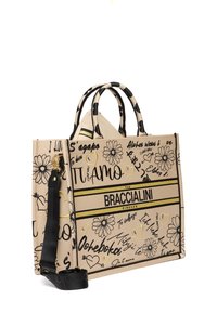 Borsa a tracolla in tela con disegni floreali neri e testo scritto a mano su sfondo beige, dotata di manici doppi e di una tracolla staccabile.