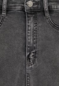 Gros plan d'un jean en denim noir avec un bouton argenté gravé "Double-Bean" et des coutures visibles sur la poche avant.
