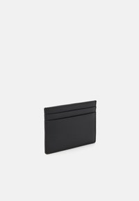 Black leather cardholder with a textured finish, featuring four card slots and a minimalist design, edged with precise stitching.