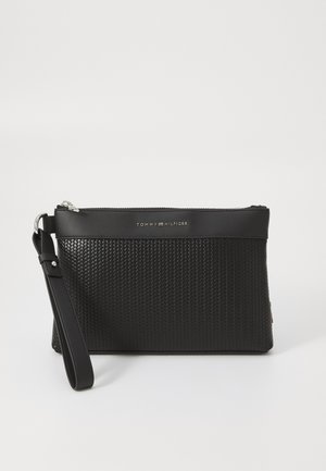 Pochette noire texturée avec fermeture éclair, logo de marque sur le devant et une bandoulière réglable pour plus de polyvalence.