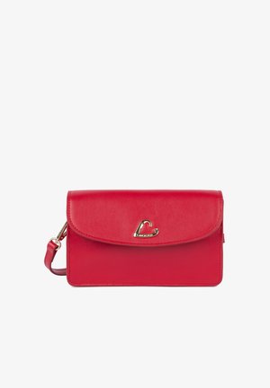 Pochette en cuir rouge avec fermoir en forme de cœur doré et sangle de poignet amovible sur fond blanc.