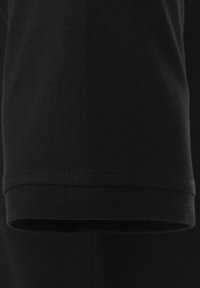 Schwarzer Baumwoll-T-Shirt-Stoff mit strukturierten Oberfläche, mit kurzen Ärmeln und einem sauberen Saum, vor einem neutralen Hintergrund präsentiert.