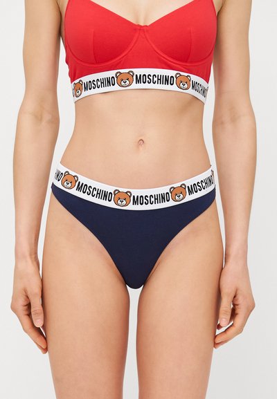 Granatowy bawełniany thong z białą elastyczną talią z logo niedźwiedzia oraz napisem "MOSCHINO". Prosty design z gładką teksturą.