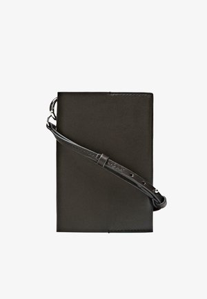 Porta taccuino in pelle nera con tracolla regolabile abbinata. Presenta una texture liscia e un design minimalista senza componenti hardware visibili.