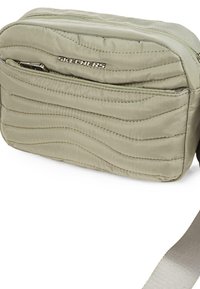 Bolso bandolera de tela acolchada de color verde claro con costuras horizontales, un cierre superior y un logo plateado de "SKECHERS" en la parte frontal.
