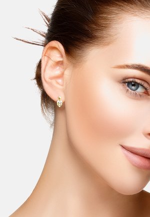 Guldbladsformade studs med en liten rund akcent. Designen har en matt finish och delikata detaljer.