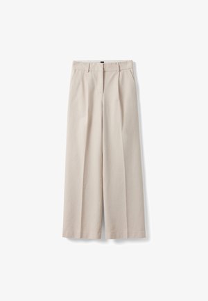 Beige wijde broek met ceintuurlussen, voorplooien, zijzakken en een sluiting aan de voorkant met knoop en ritssluiting.