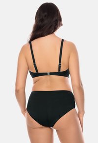 Set da bagno nero composto da un reggiseno aderente con spalline regolabili e uno slip a vita alta. Texture liscia, design minimal e senza fantasie.