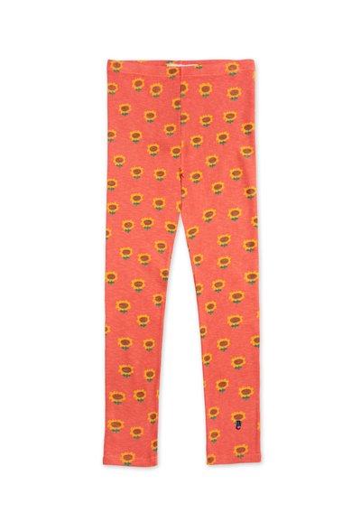 Coral leggings featuring a repeated sunflower pattern in yellow and green, made of ribbed fabric with a fitted shape and elastic waist.