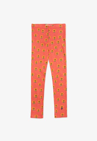 Korallleggings med ett upprepat mönster av solrosor i gult och grönt, tillverkade av ribbat tyg med en åtsittande form och elastisk midja.