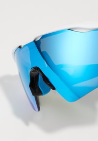 Blue-tinted sport sunglasses with a sleek design, black accents, and a wraparound shape. Features a smooth plastic frame and curved lenses.