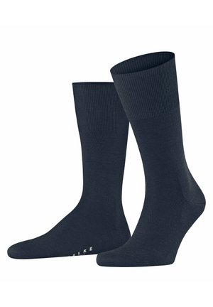 Marineblaue Socken mit einem gerippten Bündchen, glatter Textur und verstärkter Zehenpartie. Das Material scheint dehnbar zu sein, ausgelegt für Komfort und Passform.