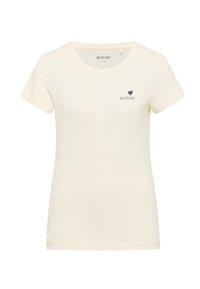 Camiseta de manga corta color crema hecha de algodón suave. Presenta un pequeño corazón oscuro y el nombre de la marca impresos cerca del cuello. Diseño sencillo.