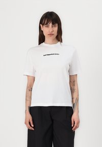 White cotton t-shirt with a crew neck, short sleeves, and a printed black logo that reads "Karl Lagerfeld Jeans" across the chest.